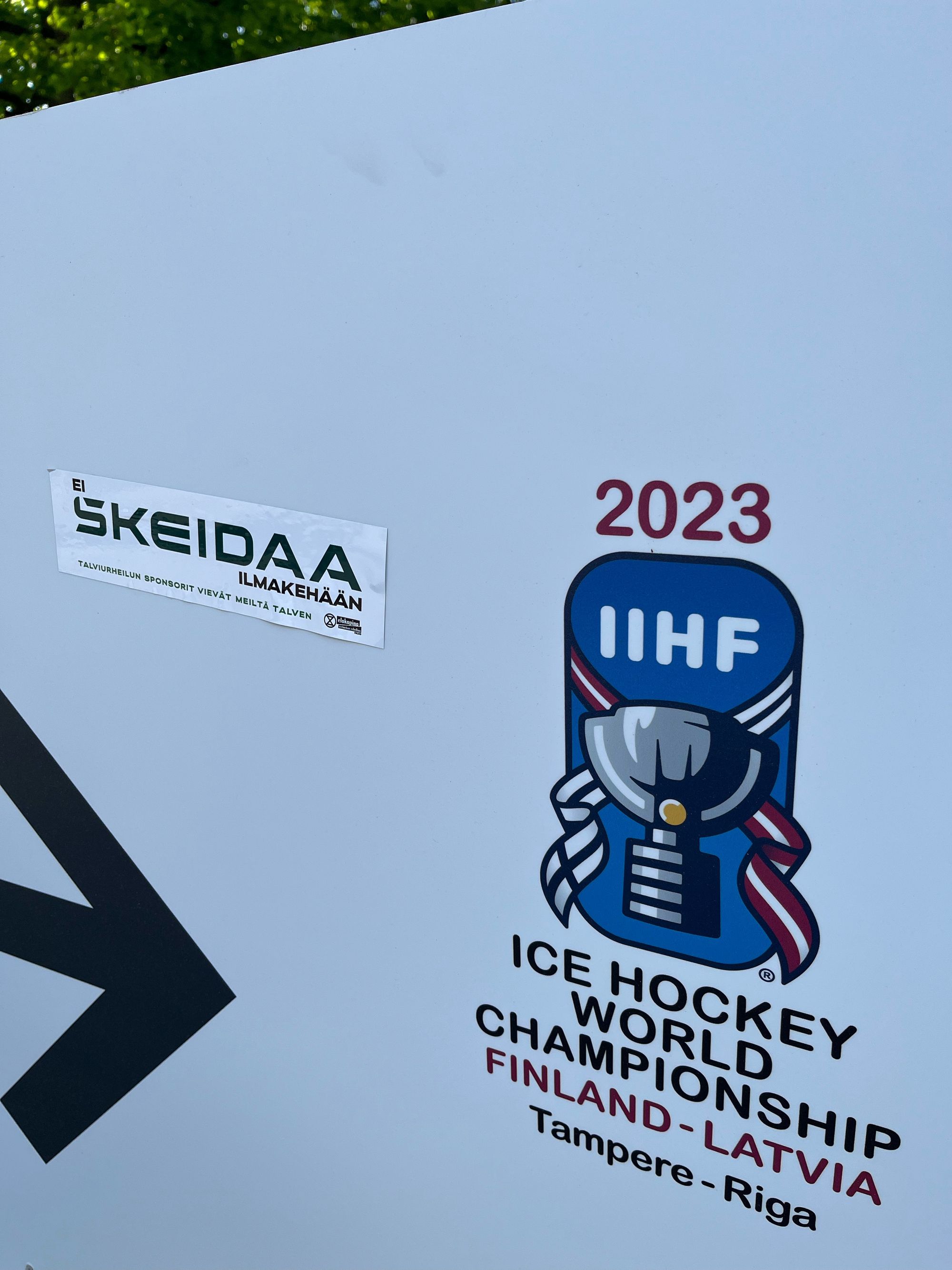 Ei skeidaa ilmakehään -tarra 2023 IIHF Ice Hockey World Championship Finland–Latvia (Tampere–Riga) -tekstien vieressä.